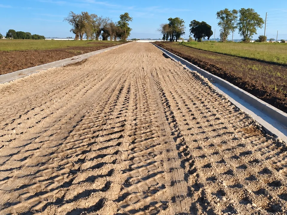 Calle de loteo con la base compactada y cordón cuneta a un costado